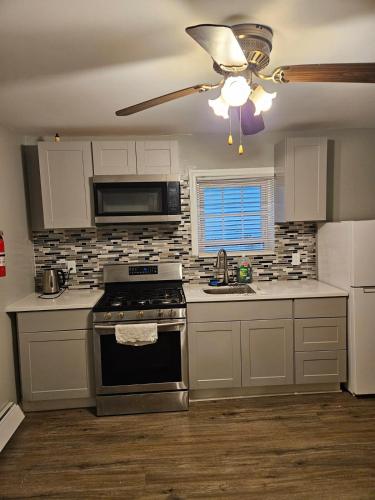 een keuken met een fornuis en een plafondventilator bij Entire Spacious House in New Jersey in East Orange