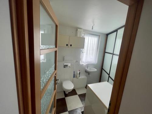 a small bathroom with a toilet and a sink at Les Dunes de Longchamp in Saint-Lunaire