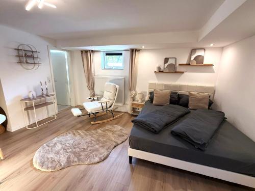 a bedroom with a large bed and a chair at Allgäu-Nest mit Stellplatz in Durach
