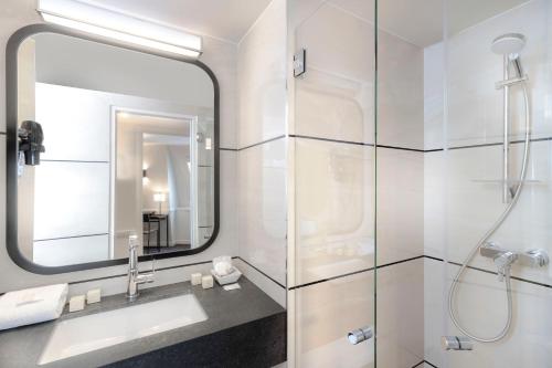 a bathroom with a sink and a mirror at Elysées Union in Paris