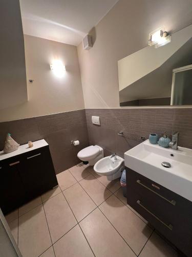 a bathroom with a toilet and a sink and a mirror at Mondarco in Serravalle
