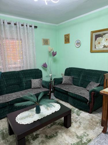 a living room with two green couches and a table at Sweet Escape in Shkodër