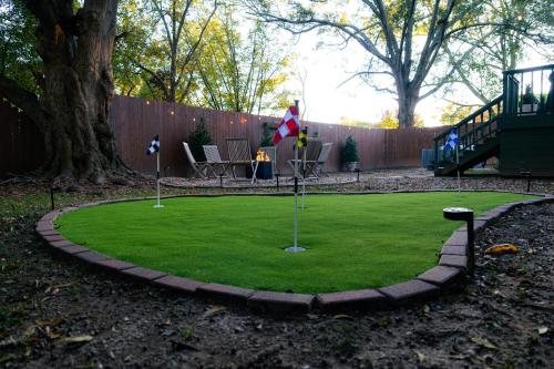 a miniature golf course in a backyard with a tree at Speakeasy, Hot Tub, Putt Putt, Outdoor Theatre, 8 minutes from Downtown Greenville in Greenville