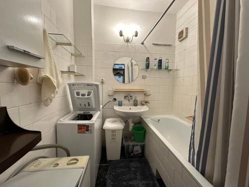 a small bathroom with a sink and a bath tub at Retro apartment with three rooms in Bratislava