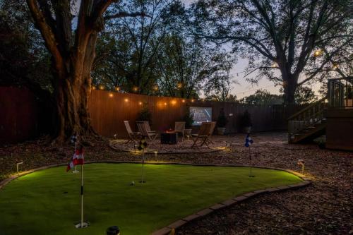 a miniature golf course in a backyard at night at Speakeasy, Hot Tub, Putt Putt, Outdoor Theatre, 8 minutes from Downtown Greenville in Greenville