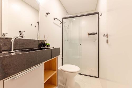 a bathroom with a shower and a toilet and a sink at Apartamento Lindíssimo na Praia de Bombas in Bombas
