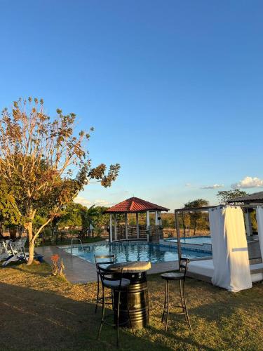 a patio with a table and chairs next to a pool at Hotel Fazenda Vitoria in Pindorama