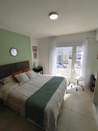 ein Schlafzimmer mit einem großen Bett und einem großen Fenster in der Unterkunft Departamento Céntrico in Río Grande
