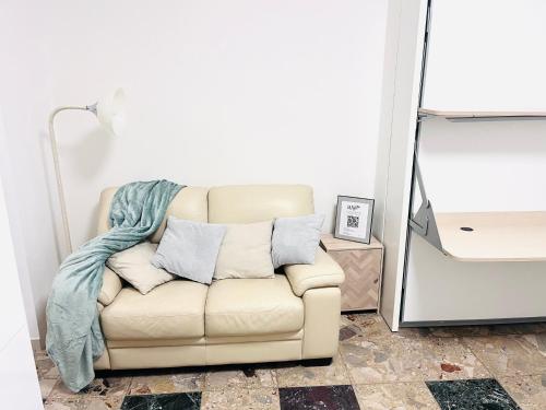 a couch with a blanket on it in a living room at Roxy House Sesto San Giovanni 300mt MetroRondó in Sesto San Giovanni