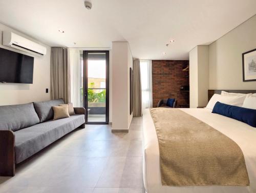 メデジンにあるLaureles Selection Suitesの大きなベッドとソファのある寝室