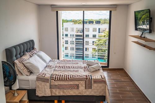 a bedroom with a bed and a large window at Modern loft and parking ideal for couples in Acacías