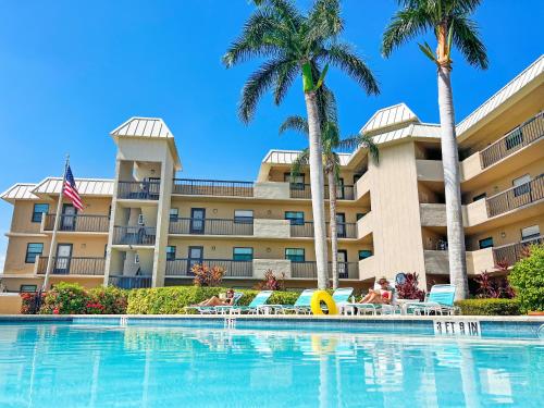 ein Resort mit Swimmingpool und Palmen in der Unterkunft End Unit Steps from Beach Access w/ No Crazy Beach Prices in Marco Island