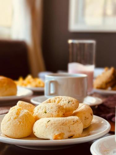Un plato de pan sobre una mesa con una taza de café. en Taj Hotel, en Três Lagoas