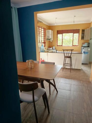 a dining room and kitchen with a wooden table and chairs at Kio Farm Retreat in Kiserian