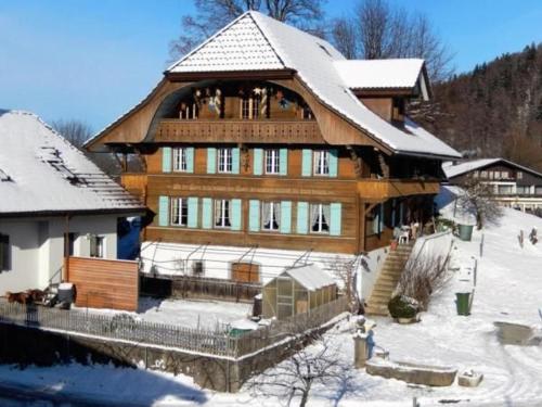 a large wooden house with snow on the roof at Haus Itten in Hondrich