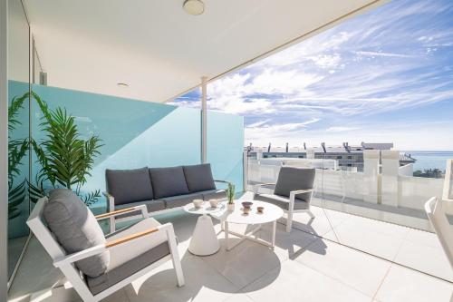 a balcony with a couch and chairs and a table at Med2holidays in Fuengirola