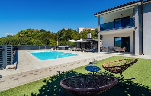 ein Haus mit einem Pool und zwei Stühlen in der Unterkunft Beautiful Home In Imotski in Imotski