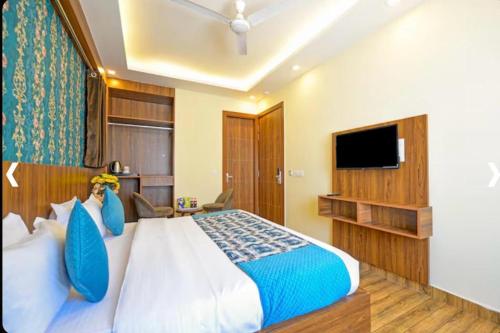 Un dormitorio con una cama grande y un televisor. en Hotel Verano, en Nueva Delhi