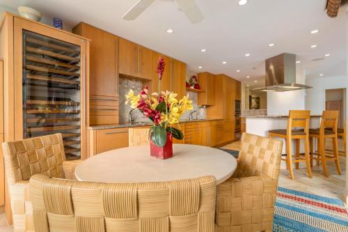 eine Küche mit einem Tisch mit einer Vase mit Blumen darauf in der Unterkunft Kaanapali Alii 2 Bedroom Oceanfront in Hyatt Regency Maui Hotel Heliport