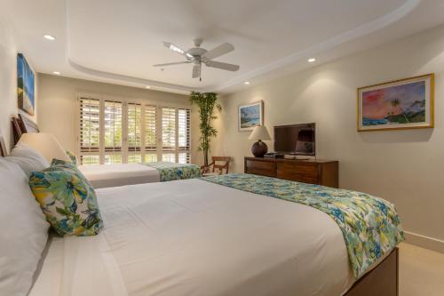 ein Schlafzimmer mit zwei Betten und einem Deckenventilator in der Unterkunft Kaanapali Alii 2 Bedroom Oceanfront in Hyatt Regency Maui Hotel Heliport