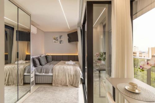 Ένα ή περισσότερα κρεβάτια σε δωμάτιο στο Varanda panorâmica | Suíte Comfort Batel