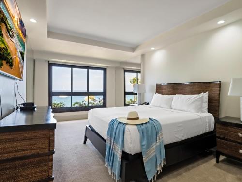 a bedroom with a bed and a desk with a hat on it at Kaanapali Alii 2 Bedroom Oceanfront in Kaanapali