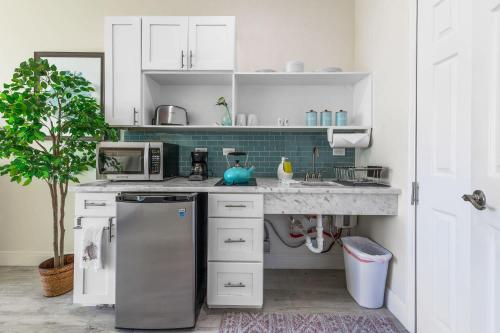 a kitchen with a sink and a refrigerator at The One Love at Cottages in Sand Bluff