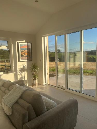 a living room with a couch and sliding glass doors at Hollowdene in Gilford
