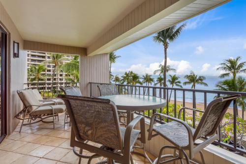 a balcony with a table and chairs and a view of the ocean at Kaanapali Alii 2 Bedroom Oceanfront in Kaanapali