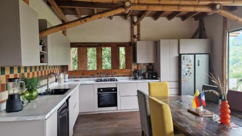 a kitchen with white cabinets and a wooden table at Cabane Limon - Salento in Salento