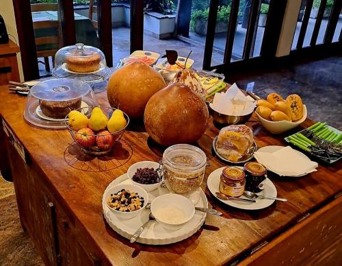 ein Holztisch mit verschiedenen Lebensmitteln darauf in der Unterkunft Casa Verde Río in Rio de Janeiro