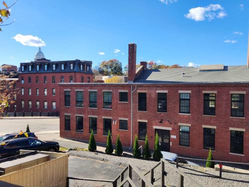 a red brick building with a car parked in front of it at Jennifer's Riverfront Loft State House Views in Providence
