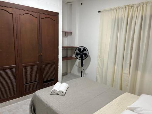 a bedroom with a bed and a dresser with towels at Apartamento 101 céntrico amplio y seguro in Cali