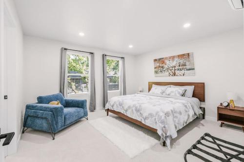 une chambre avec un lit et une chaise bleue dans l'établissement New Spacious Evergreen Home For Family Getaways, à Gresham