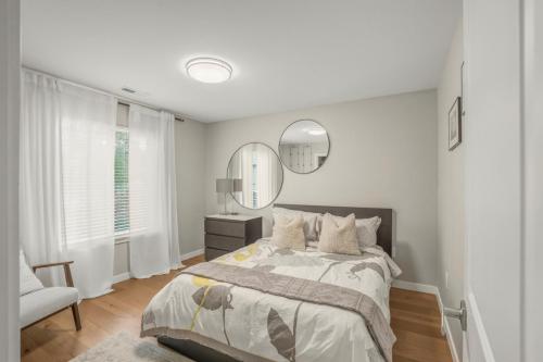 HazelwoodにあるModern Scandinavian Home, Near PDX and Downtownのベッドと鏡のある白い寝室