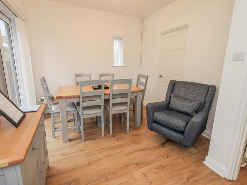 a dining room with a table and a chair at 1 Eamont Park in Penrith