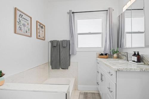 a white kitchen with a sink and a window at Pool House Retreat near LAX, SoFi & Beach in Inglewood