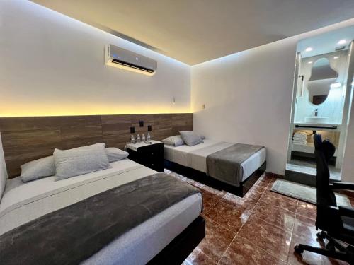 a hotel room with two beds and a mirror at Eco-Hotel boutique Casa Solar Minatitlán in Minatitlán