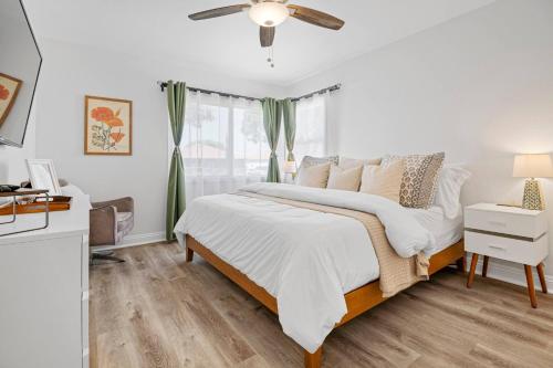 a white bedroom with a bed and a window at Pool House Retreat near LAX, SoFi & Beach in Inglewood