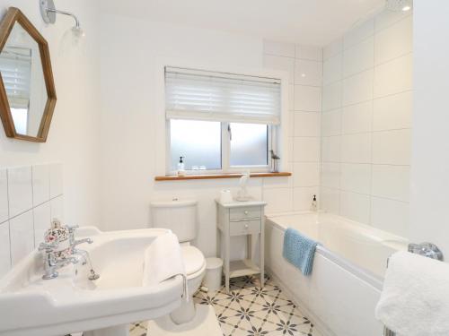 ein Badezimmer mit Badewanne, Toilette und Waschbecken in der Unterkunft Beechwood Cottage in Pitlochry