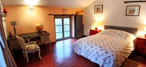 Un dormitorio con una cama, un escritorio y una mesa. en Le Ptit Cottage, en Nyons