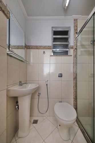 a bathroom with a toilet and a sink and a shower at Hotel Macabu in Barra Mansa