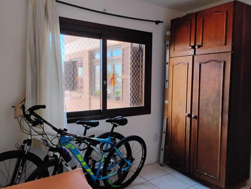 ein Fahrrad, das in einem Raum mit Fenster geparkt ist in der Unterkunft Xangrilá, um paraíso perto da praia in Xangri-lá