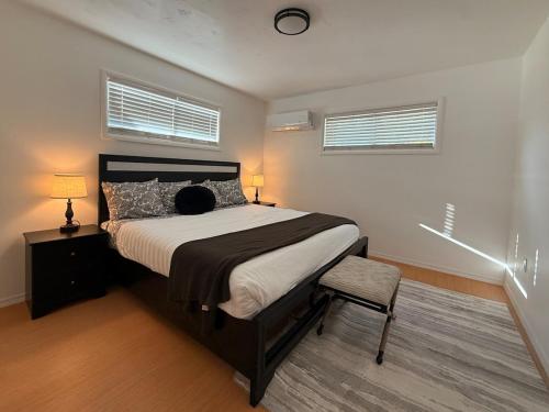 a bedroom with a bed and a chair and two windows at Golden Acres in Calming Caldwell in Caldwell