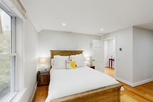 Una habitación blanca con una cama y una ventana en Mitchell Manor MV, en Vineyard Haven