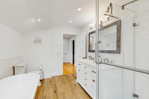 Un baño blanco con lavabo y espejo. en Mitchell Manor MV, en Vineyard Haven