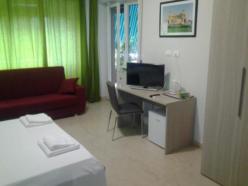 Cette chambre comprend un bureau avec un ordinateur et un canapé. dans l'établissement Olimpica Relais guest house CIR 28624, à Rome
