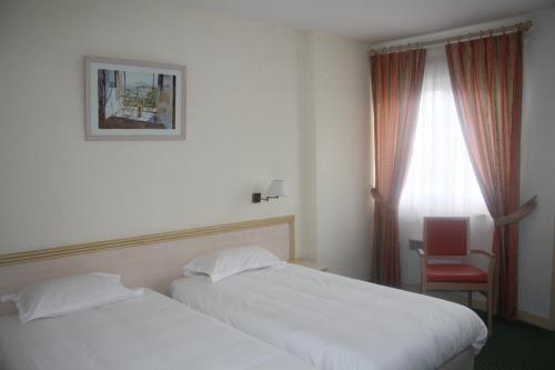 Ένα ή περισσότερα κρεβάτια σε δωμάτιο στο Le Charollais Motel Restaurant Contact-Hôtel