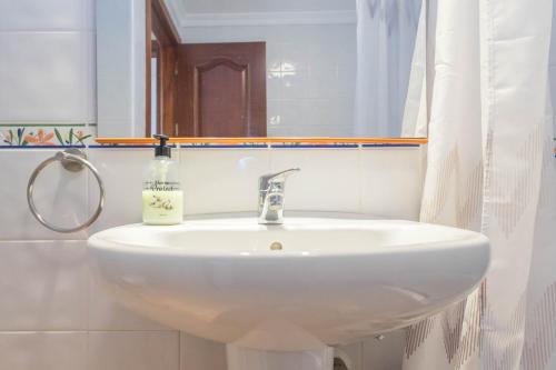 a white sink in a bathroom with a mirror at Playa Sardina Home with Pool in Sardina