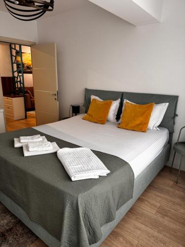a bedroom with a large bed with orange pillows at Newton Flat Apartment in Văleni